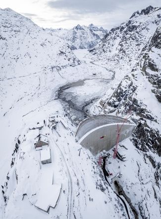 Baustelle und leerer Grimselsee in Winterlandschaft